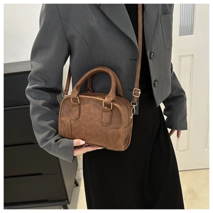 Brown vintage Boston bag with ORN logo shown with a grey blazer and black skirt