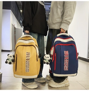 Detail view of large nylon backpack with color-contrast zippers and panda plush pendant