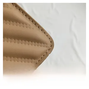 Macro detail of high-quality quilted leather texture and fine stitching on a khaki handbag