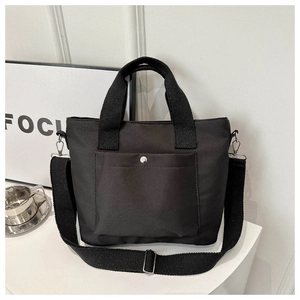 Detail der schwarzen Nylon-Tasche mit Fronttasche und silbernem Druckknopf-Verschluss