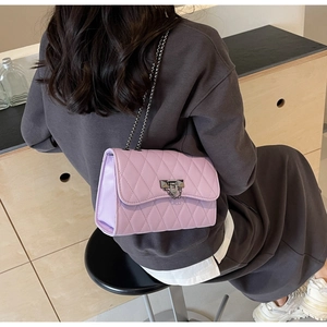 Detail of light purple quilted shoulder bag with silver chain strap and metal lock