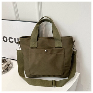 Detail der olivgrünen Nylon-Einkaufstasche mit Vordertasche und silbernem Metalldruckknopf