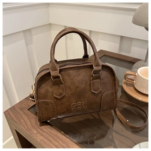 Close-up of brown vintage Boston bag with ORN ORN logo on a cozy cafe table setting