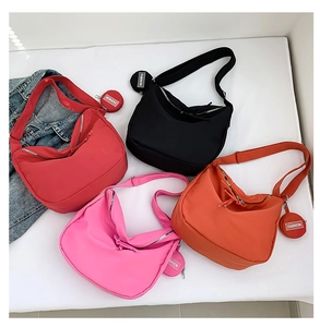 Détail de sacs fourre-tout en nylon multicolore avec porte-monnaie ronds et tissu étanche