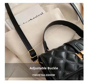 Close-up of black quilted shoulder bag featuring premium gold metal buckle and push-lock