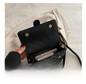 Detail of internal capacity in black quilted leather crossbody bag with gold magnetic buckle