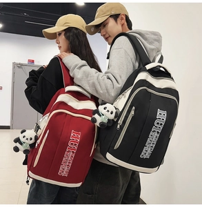 Detail of couple wearing large capacity contrast nylon backpacks with panda charms
