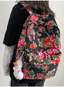Detail of backpack with traditional floral pattern and cute white duck plush charm