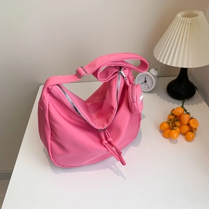 Sac à bandoulière en nylon rose avec large sangle réglable et petit porte-monnaie rond assorti