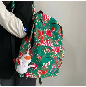 Detail view of ethnic floral backpack with green peony print and plush duck charm