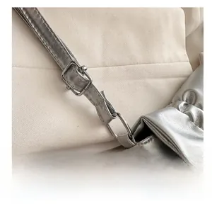 Close-up of adjustable silver textured leather shoulder strap with metallic buckle