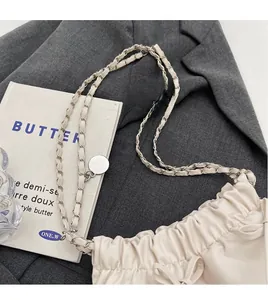Gros plan détaillé du sac seau blanc crème avec bandoulière chaîne et nœud décoratif