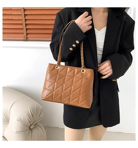 Détail du sac cabas matelassé marron avec chaîne dorée et texture en cuir élégante