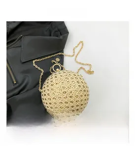 Macro shot of gold spherical evening bag featuring intricate hollow-out geometric patterns