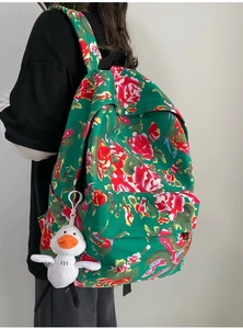 Detailed side view of ethnic floral backpack with a cute white plush duck charm