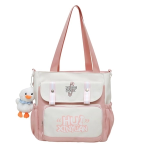 Detailed view of pink and white canvas tote bag featuring multi-pocket design and duck charm