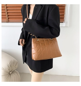 Détail du sac cabas matelassé en cuir PU caramel avec élégante bandoulière chaîne dorée