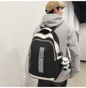 Detail shot of a black and white contrast nylon backpack with a cute panda pendant