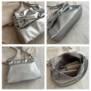 Silver tote bag with bow detail and spacious interior compartment for daily essentials