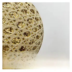 Macro shot of high quality beige crochet mesh fabric with dense gold sequins detail