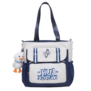 Detailed view of the blue and white student tote bag with cute duck charm accessory