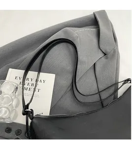 Détail du sac fourre-tout minimaliste en cuir PU noir avec bandoulière longue et fermeture