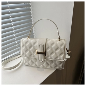 Detailed close-up of white quilted leather texture with gold metal buckle on top handle bag