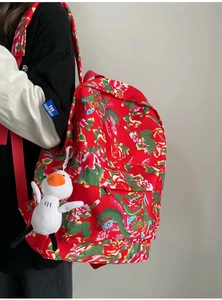 Detail of red floral backpack with traditional dragon pattern and cute duck charm