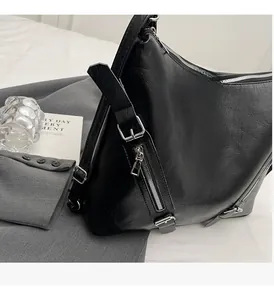 Gros plan sur la quincaillerie argentée et la fermeture éclair d'un sac cabas en cuir noir