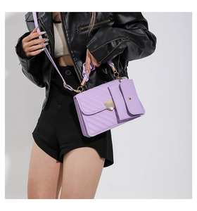 Close-up of lavender quilted handbag featuring a gold heart-shaped magnetic buckle