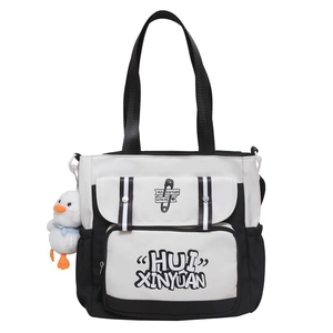 Detail of black and white tote bag with letter print and cute white duck plush charm