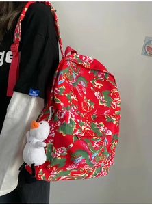 Close-up of red backpack with traditional Chinese floral patterns and plush duck pendant