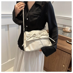 Close-up of cream soft leather tote bag with elegant pleats and delicate bow details