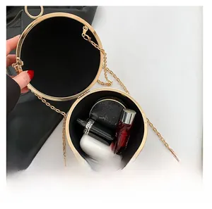 Interior capacity of golden round evening bag with chain showing cosmetics and accessories