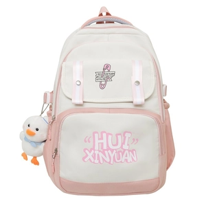 Detail of white and pink student backpack featuring a cute plush duck charm and printed text