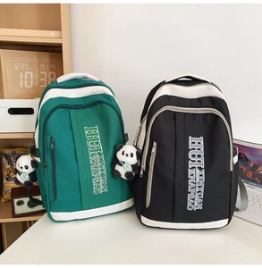 Detail view of stylish color-block nylon backpacks with cute panda pendant for students
