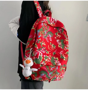 Detail of traditional Chinese floral pattern backpack with a cute goose plush keychain
