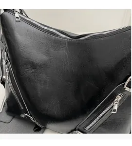 Vue détaillée du sac cabas noir avec texture grainée et fermetures éclair en métal argenté
