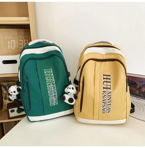 Detail of dark green and yellow large capacity school backpacks with panda keychain