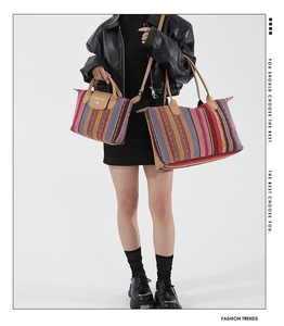 Detail of two-piece striped tote bags with leather handles and fashion lettering