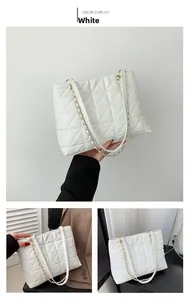 Détail du sac cabas matelassé blanc avec bandoulière chaîne dorée et coutures triangles