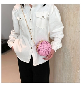 Detail of a sparkling hot pink spherical evening bag with rhinestones and a gold chain strap