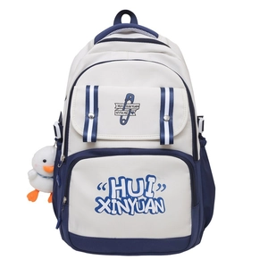 Close-up of white and navy blue contrast school backpack with plush duck charm