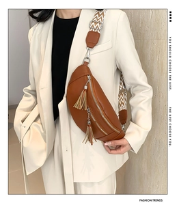 Détail du sac banane croissant en cuir marron avec glands et bandoulière à motifs