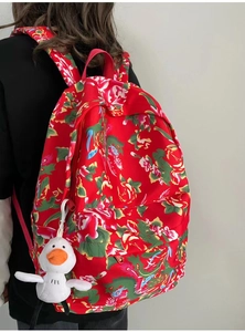 Detail of red floral canvas backpack with traditional peony pattern and plush duck charm
