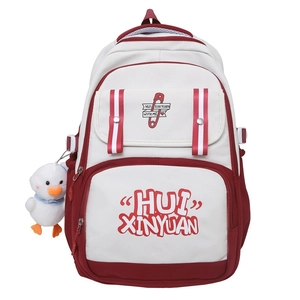Close-up of a red and white canvas backpack featuring a decorative duck pendant