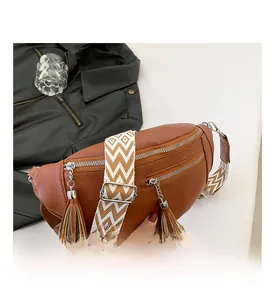 Détail du sac banane en cuir litchi marron avec double fermeture éclair et glands