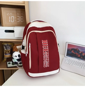 Detail of burgundy and white contrast backpack with multi-layer zippers and panda charm