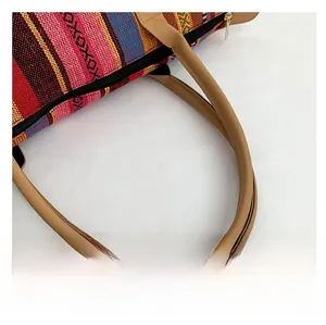 Close-up of contrast woven fabric tote bag with premium leather handles and golden zipper