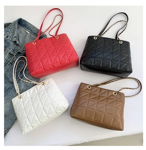 Détail de quatre sacs cabas matelassés à triangles avec chaînes en rouge, noir, blanc et brun